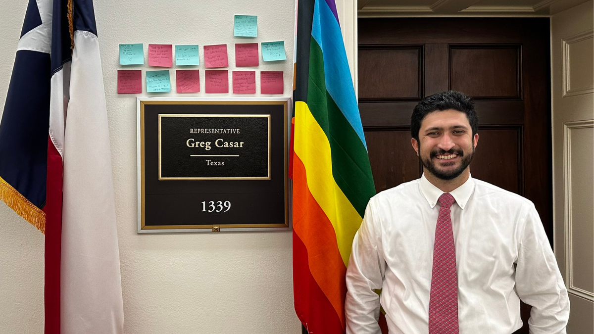 Congressman Casar in front of a rainbow flag