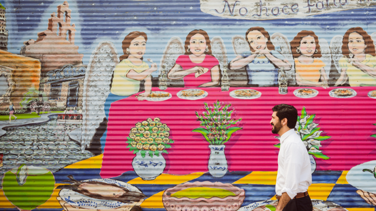 Congressman Casar walking by a local mural