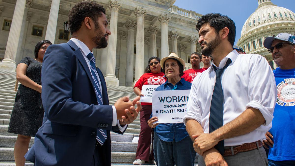 Congressman Greg Casar talks with Congressman Maxwell Frost as Dolores Huerta looks on.