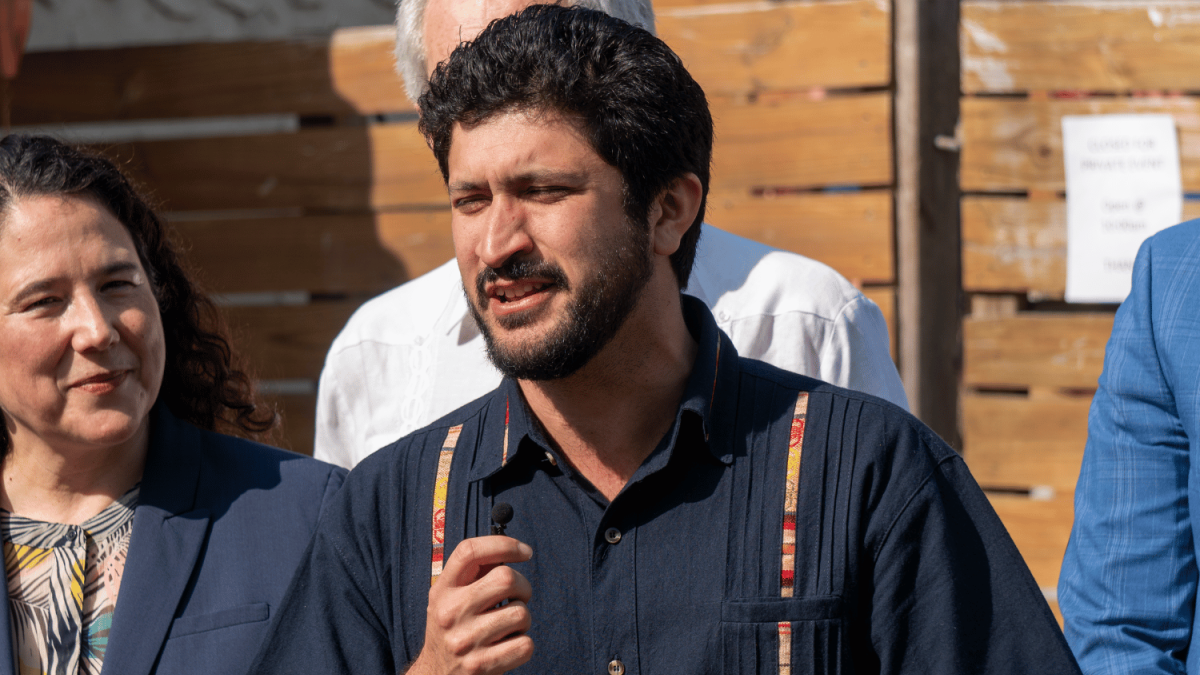 Congressman Greg Casar speaking into microphone to constituents